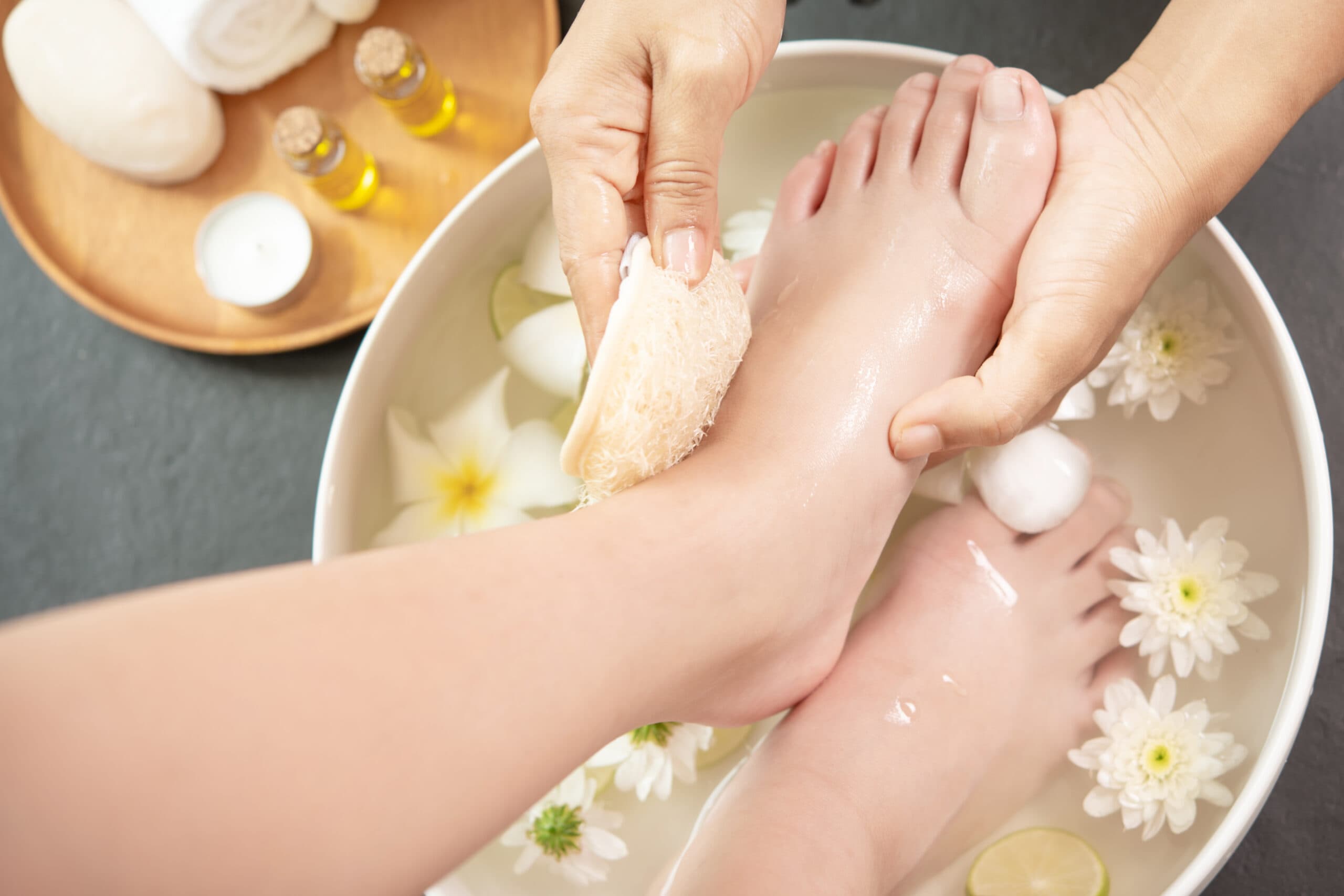 Feet being gently cleansed in a warm-water bowl during the Foot Ritual